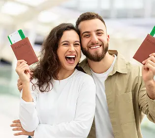 man-woman-holding-up-passports-airport-smiling-camera